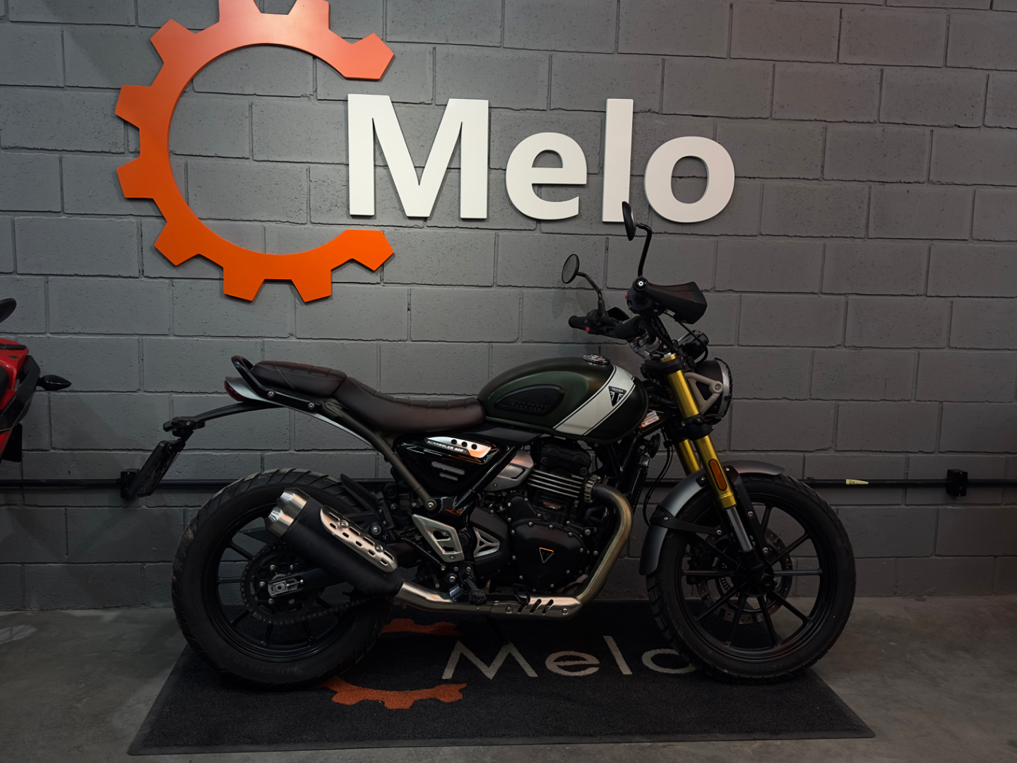 Triumph Scrambler 400X 2025 VERDE ESCURO no showroom da Melo Motos